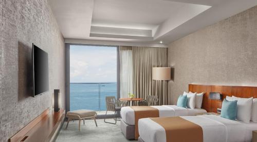 a hotel room with two beds and a view of the ocean at The Reef Island Resort Mactan, Cebu in Mactan