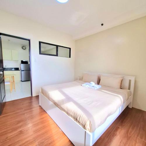 a white bed in a room with a wooden floor at BREATHTAKING BAYVIEWS - 1-5 BR Luxury and Superior Condos with Panoramic Bay Views, Balcony, Gym, Pool & Netflix - Housekeeping Available - in Manila