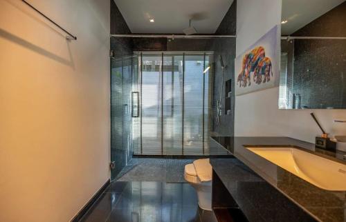 une salle de bain avec toilettes, lavabo et miroir dans l'établissement Luxury Pool Villa Resort Style Near Laguna Area, à Laguna Phuket