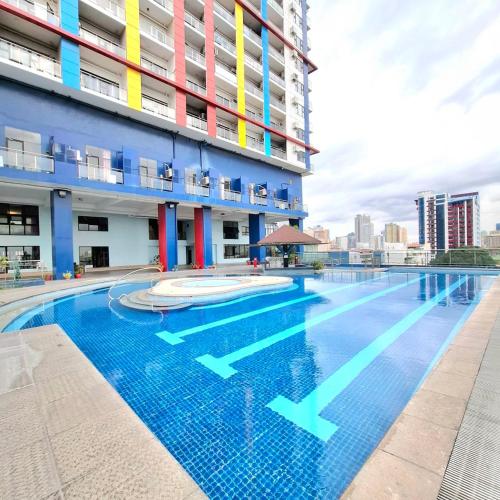 a swimming pool in front of a building at BREATHTAKING BAYVIEWS - 1-5 BR Luxury and Superior Condos with Panoramic Bay Views, Balcony, Gym, Pool & Netflix - Housekeeping Available - in Manila