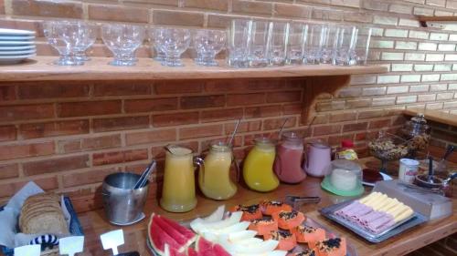 a table with many glasses and food on it at Pousada Recanto das Águas in Lumiar