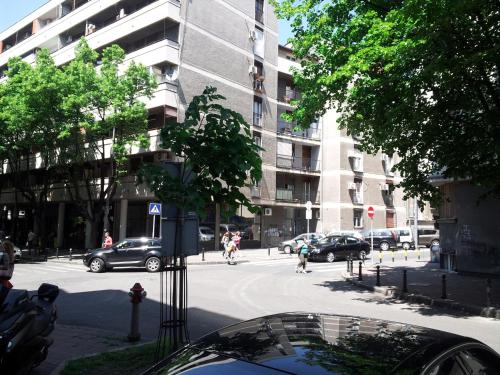 una calle de la ciudad con coches aparcados frente a un edificio en Downtown Belgrade Apartments - CHERRY, en Belgrado