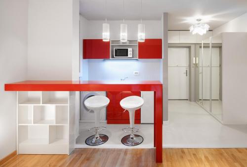 a kitchen with a red counter and stools at Downtown Belgrade Apartments - CHERRY in Belgrade