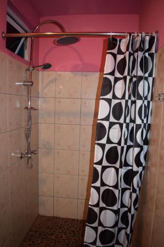 a shower with a black and white shower curtain at Baywatch Apartment in La Gaulette