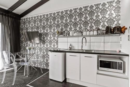 a kitchen with white appliances and a table with chairs at Orewa Beachcomber in Orewa