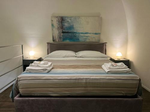 a bedroom with a bed with two towels on it at SanBiagio, 25 Guesthouse in Naples