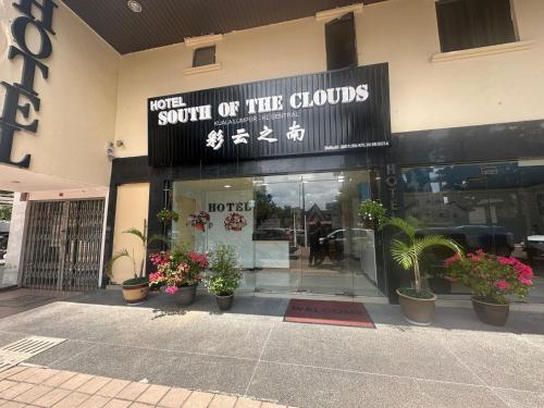 a store front with potted plants in front of it at South of The Clouds HOTEL KL Sentral 吉隆坡彩云之南酒店-中央车站店 in Kuala Lumpur
