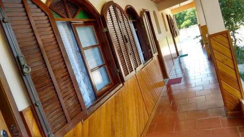 an entrance to a house with wooden doors and windows at Pousada Recanto das Águas in Lumiar