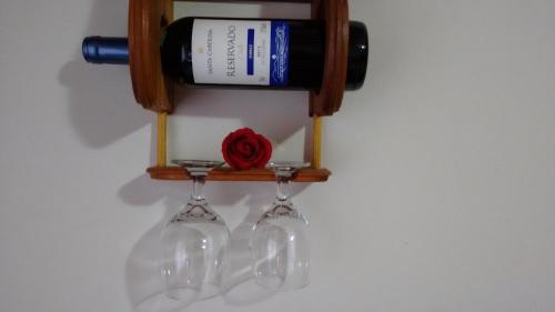 a wine rack with wine glasses and a bottle at Pousada Recanto das Águas in Lumiar