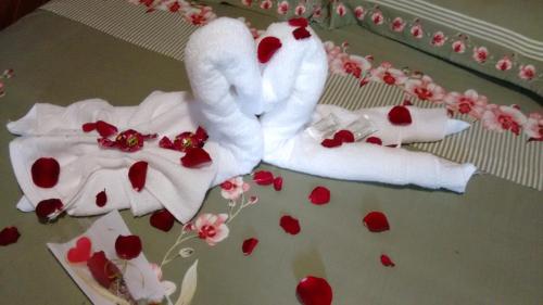 two swans made out of towels on a bed with hearts at Pousada Recanto das Águas in Lumiar