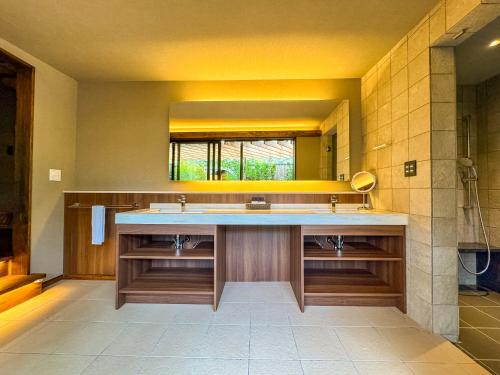 a bathroom with a sink and a large mirror at 天神郷 昊 in Tenjingō