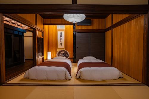 two beds in a room with wood paneling at 天神郷 昊 in Tenjingō