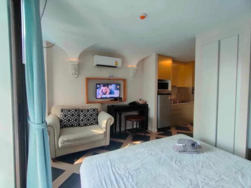 ジョムティエンビーチにあるEspanna condo jomtien By SuneeyaA9のベッド、ソファ、テレビが備わる客室です。