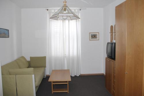 ein Wohnzimmer mit einem Sofa und einem TV in der Unterkunft Garni Brunnenhof in Kaltern