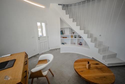 a white room with a staircase and a wooden table at Zen Blue Mills - Luxury Villa in Kea Island in Koundouros