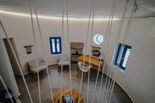 a room with a table and chairs and a swing at Zen Blue Mills - Luxury Villa in Kea Island in Koundouros