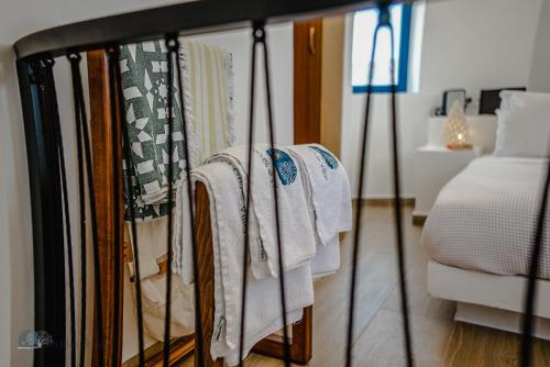 a group of towels hanging on a rack next to a bed at Zen Blue Mills - Luxury Villa in Kea Island in Koundouros