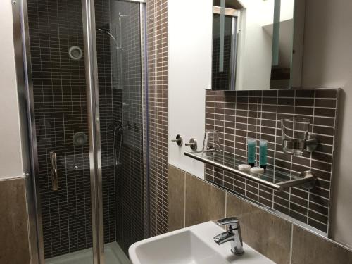 a bathroom with a shower and a sink and a mirror at Kings Head in Capel Hendre