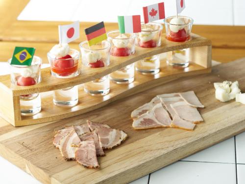 a wooden tray with sandwiches and desserts on it at Hotel Village in Asago
