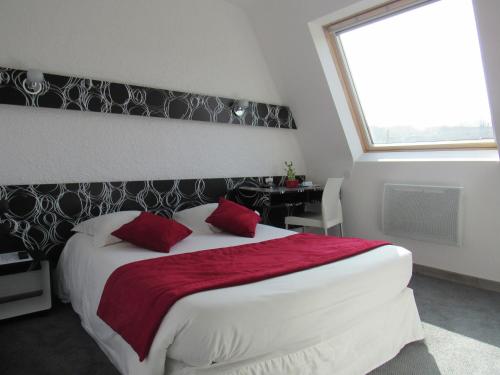 a bedroom with a white bed and white walls at Citotel Les Sternes in Perros-Guirec