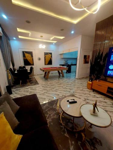 a living room with couches and a pool table at 3Bed Profssnal & Family Friendly with Swimming pool, Work Stns, PS5, Gym & near Beaches in Lagos