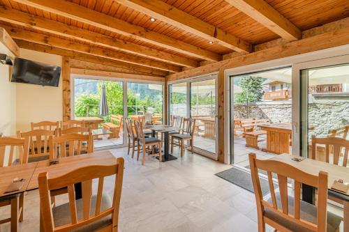 ボヴェツにあるPenzion Hosnar, apartma Muchoのテーブルと椅子と窓のあるダイニングルーム