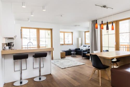 a kitchen and living room with a table and chairs at A Casa Residenz in Sölden