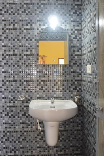 a bathroom with a sink and a mirror at C Pearl in Majorda