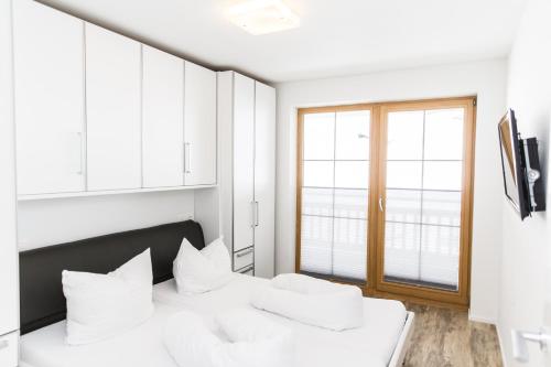 a bedroom with a bed with white pillows and a window at A Casa Residenz in Sölden