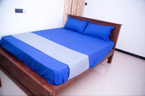 a bed with blue sheets and blue pillows in a room at Gin Green Villa in Galle