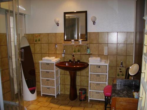 een badkamer met een wastafel en een spiegel bij A L'Ombre du Mont St Michel in Huisnes-sur-Mer