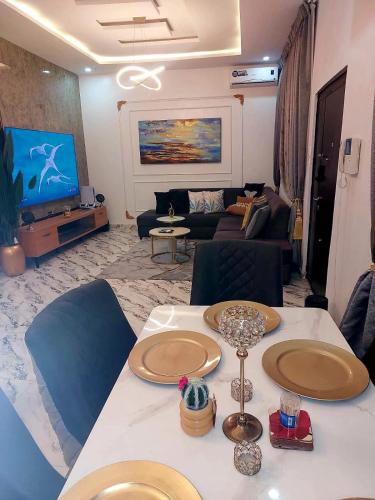 a living room with a table with plates on it at 3Bed Profssnal & Family Friendly with Swimming pool, Work Stns, PS5, Gym & near Beaches in Lagos