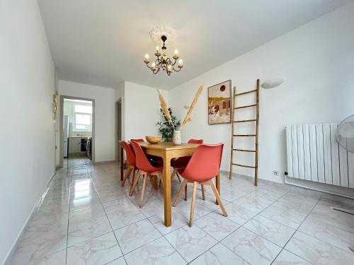 une salle à manger avec une table et des chaises rouges dans l'établissement Dahlias- 6 pers Vrai tout à pied, à Saint-Raphaël
