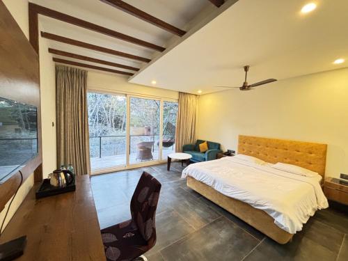a bedroom with a bed and a large window at Zeenath Taj Gardens in Yelagiri
