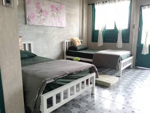 a bedroom with two twin beds and a window at โรงแรมมีวาสนา - Me Vadsana Hotel in Ban Thung Yao