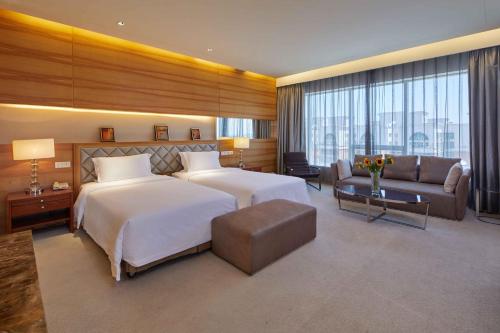 a large hotel room with two beds and a couch at HJ International Hotel in Dongguan