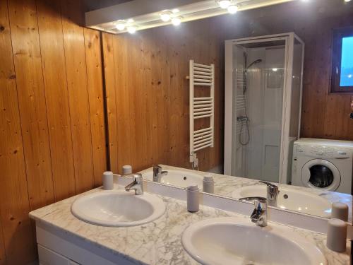 a bathroom with two sinks and a large mirror at Au repos près du lac in Vertamboz