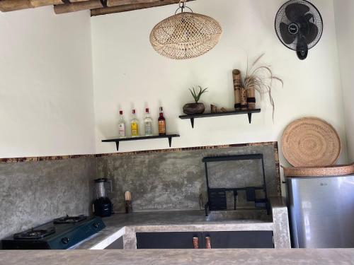 a kitchen with a sink and a stove and shelves at MoonBag Bungalows in Gili Air