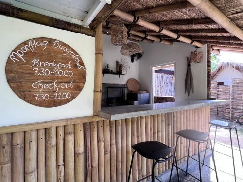 a bar with stools and a sign on the wall at MoonBag Bungalows in Gili Air