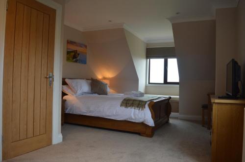 a bedroom with a bed and a window and a television at The Tide in Dunvegan