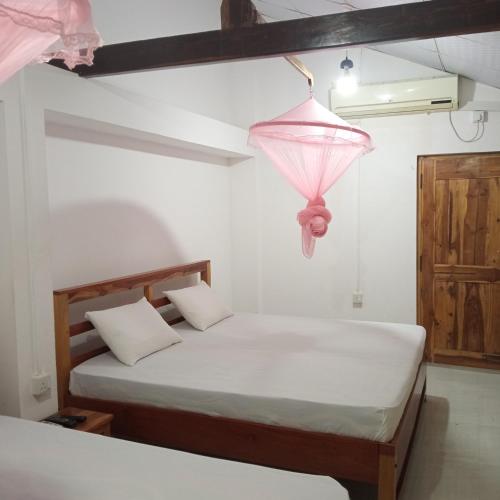een slaapkamer met een bed en een roze lamp bij 1907 Park View in Anuradhapura