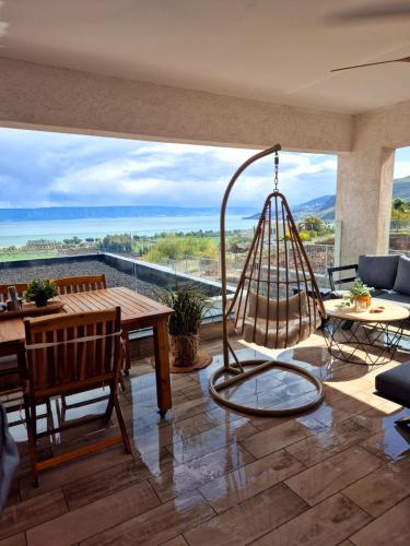 a living room with a table and a swing at הדירה- C Lake, סי כנרת in Migdal