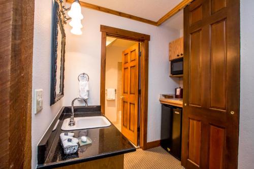 a small kitchen with a sink in a room at Kandahar Lodge at Whitefish Mountain Resort in Whitefish