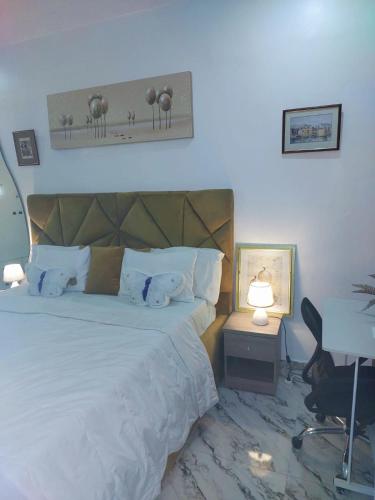 a bedroom with a bed and a desk with a lamp at 3Bed Profssnal & Family Friendly with Swimming pool, Work Stns, PS5, Gym & near Beaches in Lagos