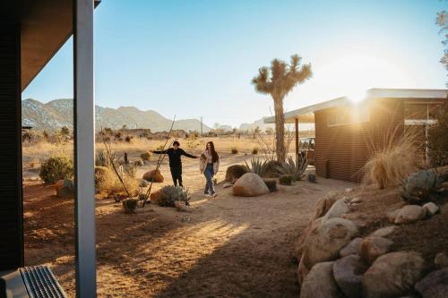 two people walking down a dirt road in the desert at Steel & Solace By The Cohost Company in Pioneertown