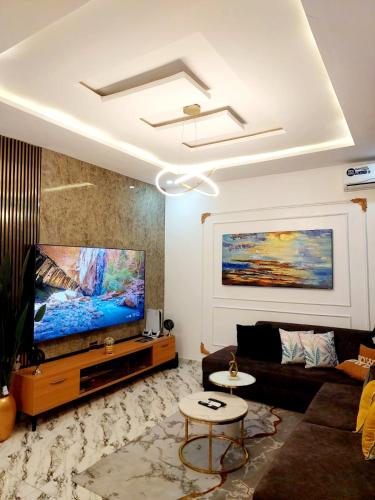 a living room with a large flat screen tv at 3Bed Profssnal & Family Friendly with Swimming pool, Work Stns, PS5, Gym & near Beaches in Lagos