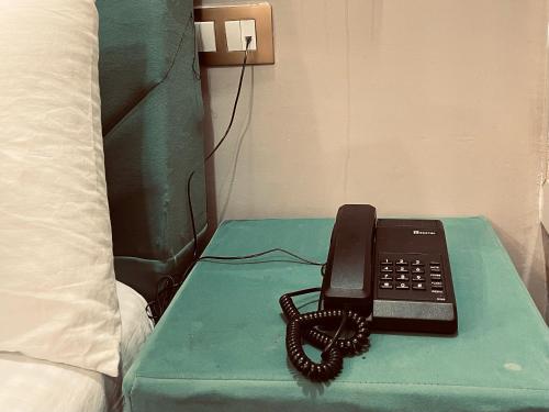 a telephone sitting on a table next to a bed at Siyavar Palace in Orchha