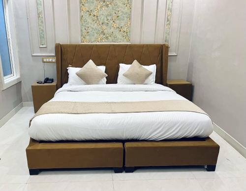 a bed with white sheets and pillows in a room at Siyavar Palace in Orchha