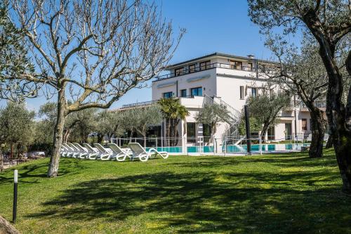 a building with a pool in front of a park at Hotel Ideal in Sirmione