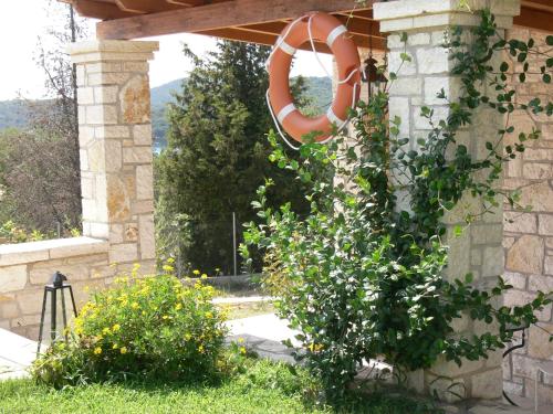 a garden with a lifesaver hanging from a pergola at Alkyon Villas in Sivota